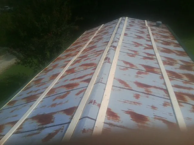 Rusted metal roof panels with new wood purlins before replacement — Storm Damage Roof Repair in Colliers by Roofing Brothers